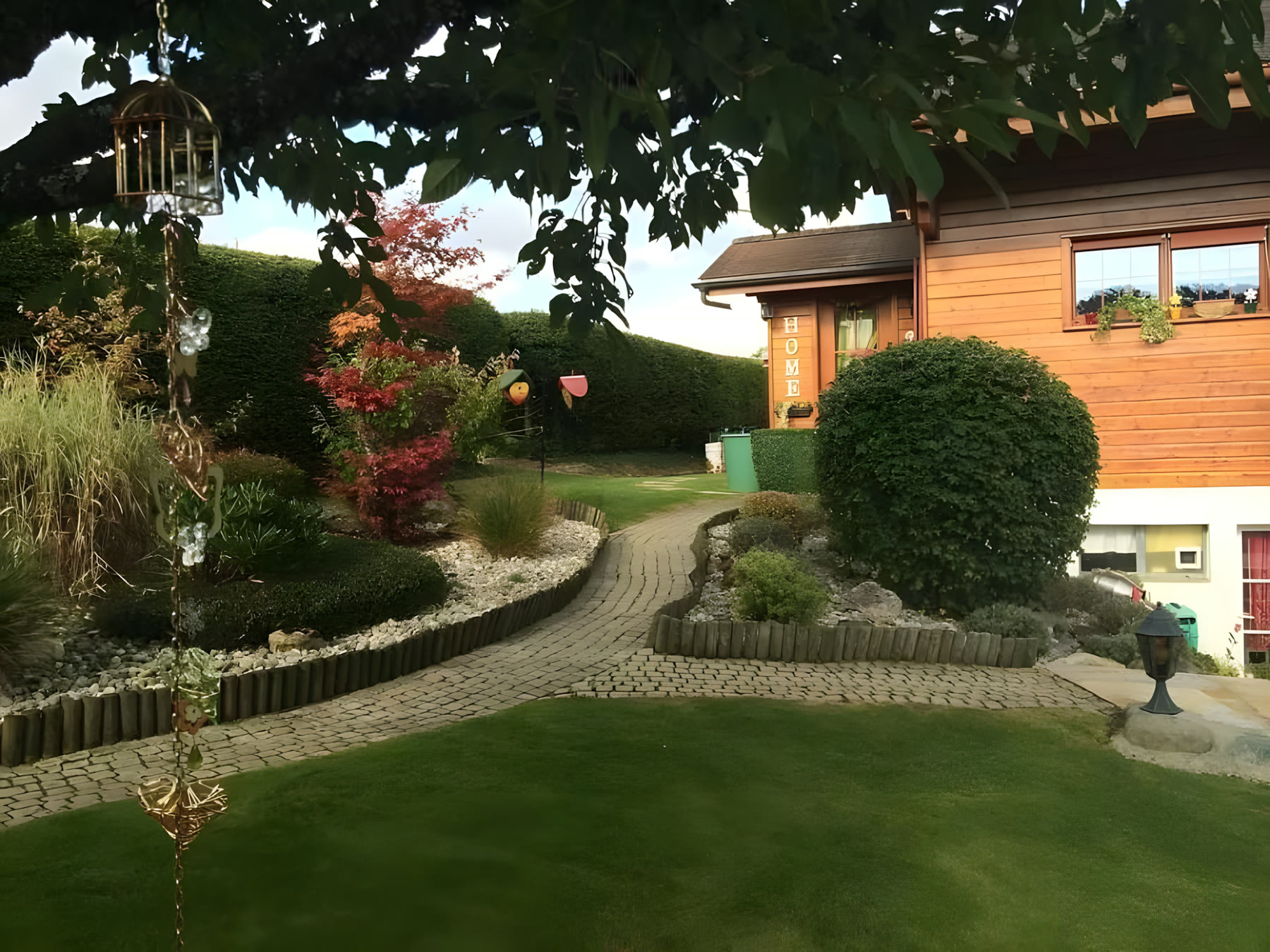 Allée pavée et massifs devant une maison